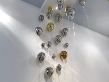 Installation décorative haut de gamme avec des ballons chromés argent et or Fuoriluogo Milano, sculptures en polyéthylène effet miroir.