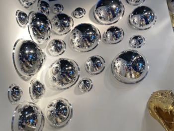 nstallation murale de bulles chromées Chrome Bubbles Fuoriluogo Milano, demi-sphères miroir de différentes tailles pour décoration design contemporaine.