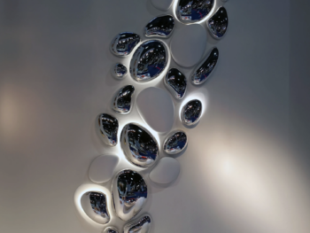 Installation murale artistique en cascade de gouttes chromées miroir Chrome Drops Fuoriluogo Milano, décoration design haut de gamme.